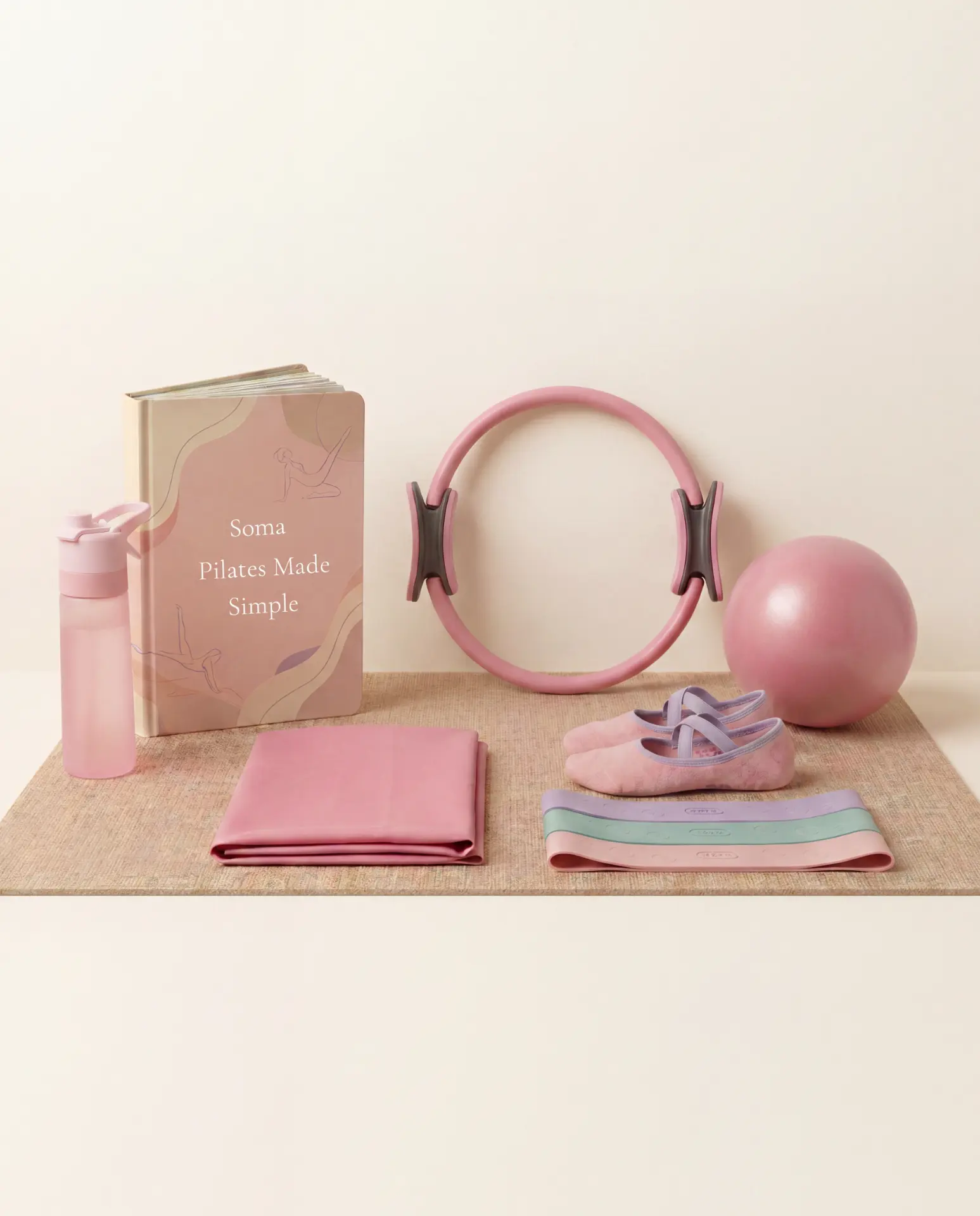 Complete Soma Pilates Essentials Kit flat lay including Pilates ring, exercise ball, resistance bands, grip socks, water bottle, and beginner guide